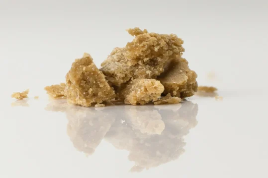 Close-up image of THCA live rosin, showcasing its golden, glossy texture and rich, sticky consistency, presented on a dab tool with a clean background, highlighting the purity and craftsmanship of this cannabis concentrate.