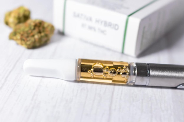 THCA cartridge lying next to weed buds